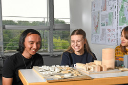 Cover image Students Models Students sit in front of building models.