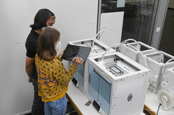 CAD, 3D Modell Students stand in front of 3D printers and assess progress.